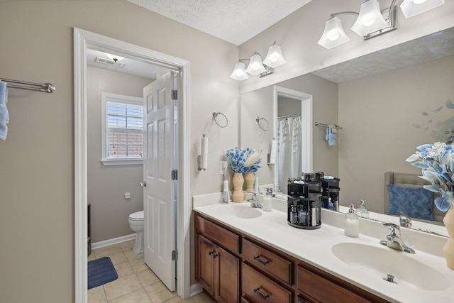 bathroom with vanity, tile patterned floors, a textured ceiling, and toilet