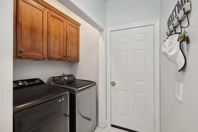 laundry area with washer and dryer and cabinets