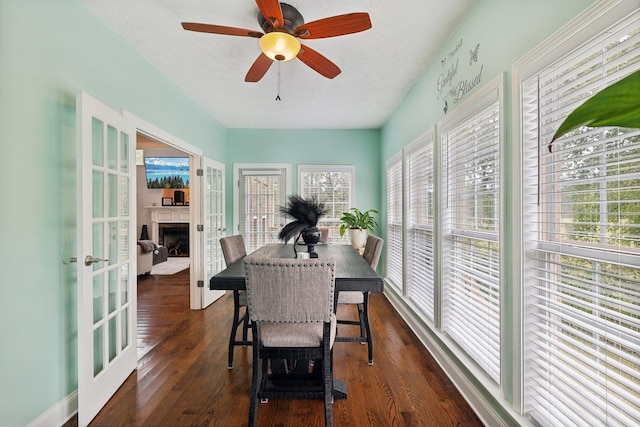 dining area featuring ceiling fan, french doors, dark wood-type flooring, and a textured ceiling