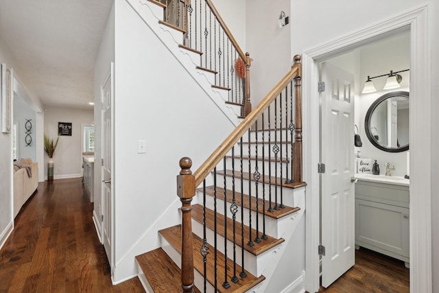 stairway featuring wood-type flooring and sink