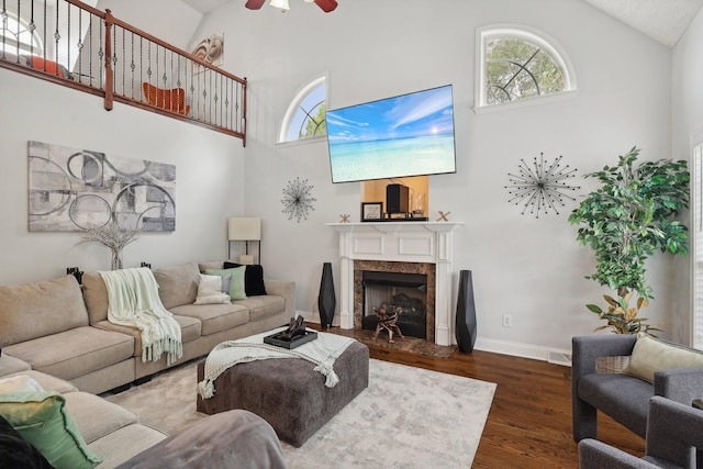 living room featuring ceiling fan, a fireplace, high vaulted ceiling, and dark hardwood / wood-style floors