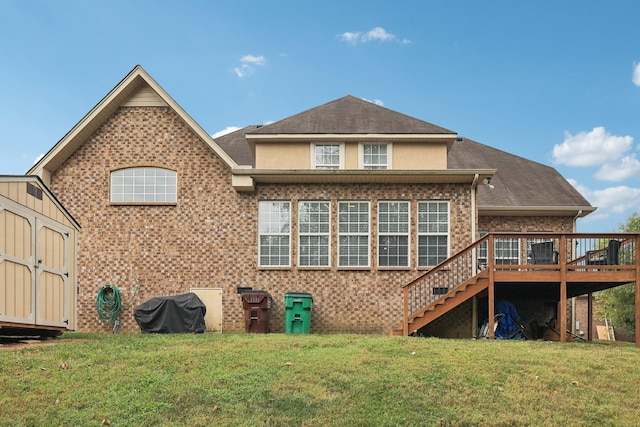 rear view of house with a lawn, a shed, and a wooden deck