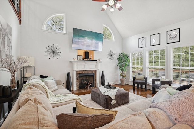 living room featuring a high end fireplace, hardwood / wood-style flooring, high vaulted ceiling, and ceiling fan