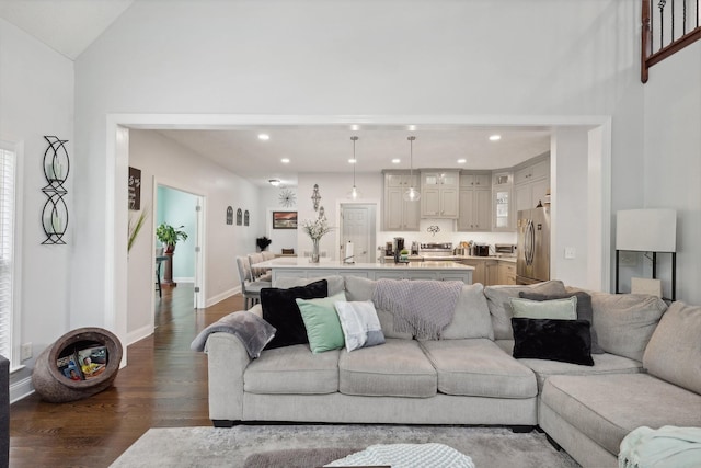 living room featuring dark wood-type flooring and vaulted ceiling