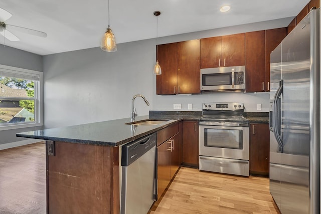 kitchen featuring kitchen peninsula, sink, hanging light fixtures, and appliances with stainless steel finishes