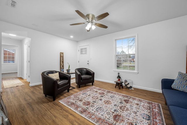 living area with ceiling fan and dark hardwood / wood-style floors