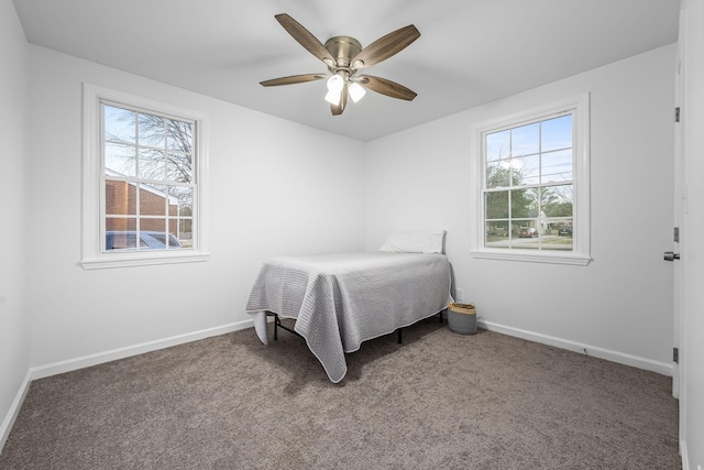 carpeted bedroom with ceiling fan and multiple windows