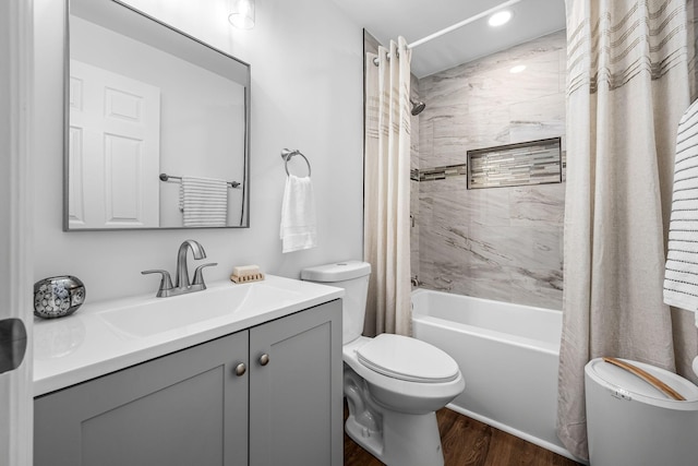 full bathroom featuring toilet, hardwood / wood-style floors, vanity, and shower / tub combo with curtain