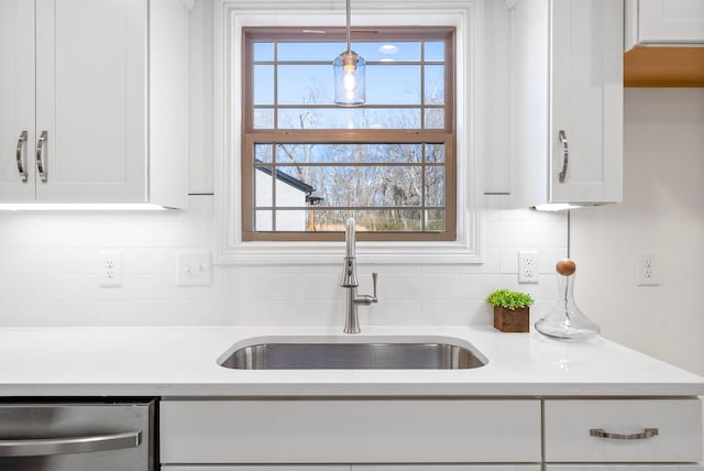 kitchen with sink, tasteful backsplash, decorative light fixtures, dishwasher, and white cabinets