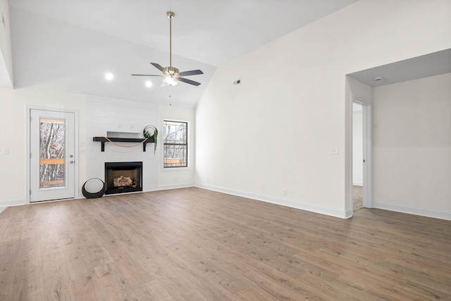 unfurnished living room featuring wood-type flooring, a large fireplace, high vaulted ceiling, and ceiling fan