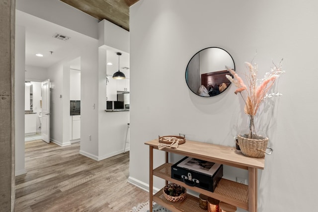 hallway with light hardwood / wood-style floors