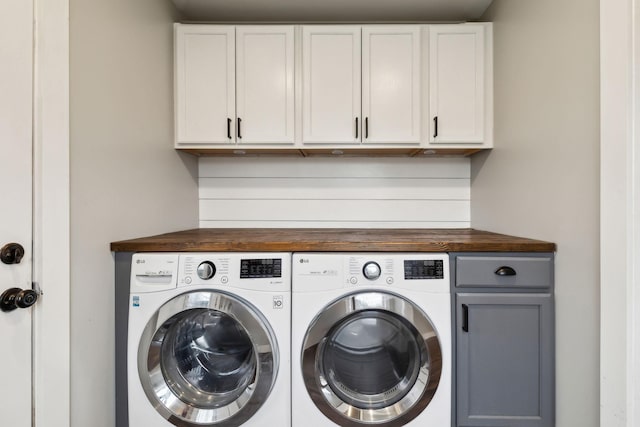 laundry area with separate washer and dryer and cabinets