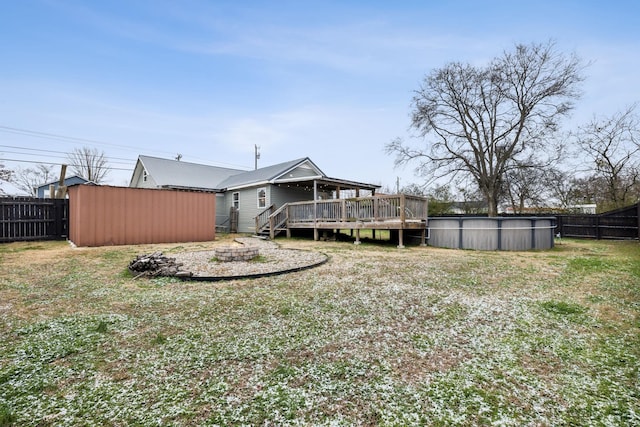 rear view of house featuring a pool side deck and a lawn