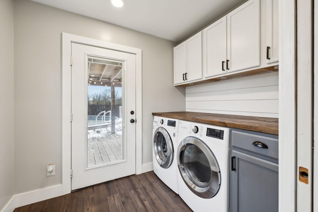 laundry area featuring washing machine and clothes dryer, cabinets, and dark hardwood / wood-style floors