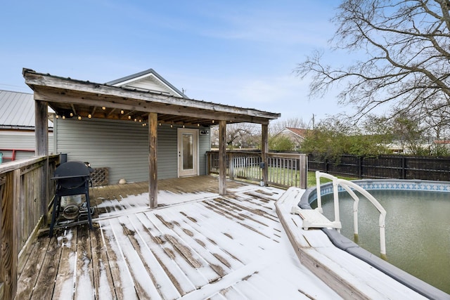 wooden terrace with a fenced in pool and a grill