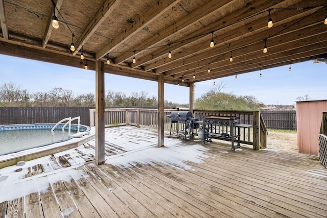 deck with a grill and an empty pool