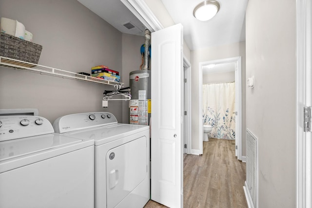 laundry room featuring separate washer and dryer, gas water heater, and light wood-type flooring