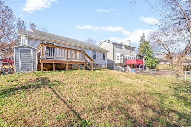 back of house with a wooden deck, a yard, and a shed