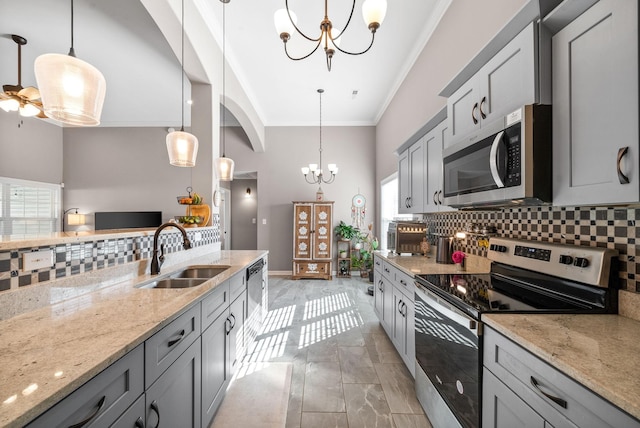 kitchen featuring sink, gray cabinets, tasteful backsplash, decorative light fixtures, and stainless steel appliances