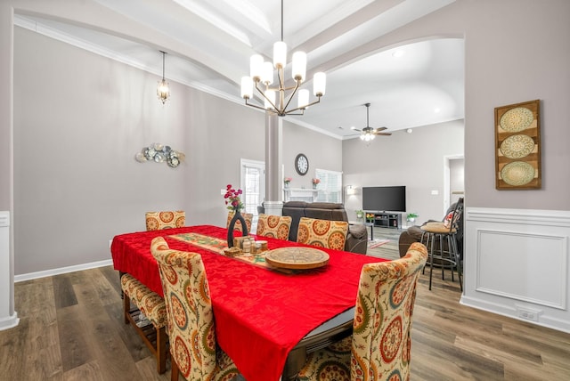 dining space with hardwood / wood-style floors, ceiling fan with notable chandelier, and ornamental molding