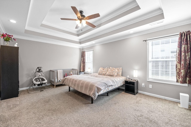 carpeted bedroom with a raised ceiling, ceiling fan, and ornamental molding