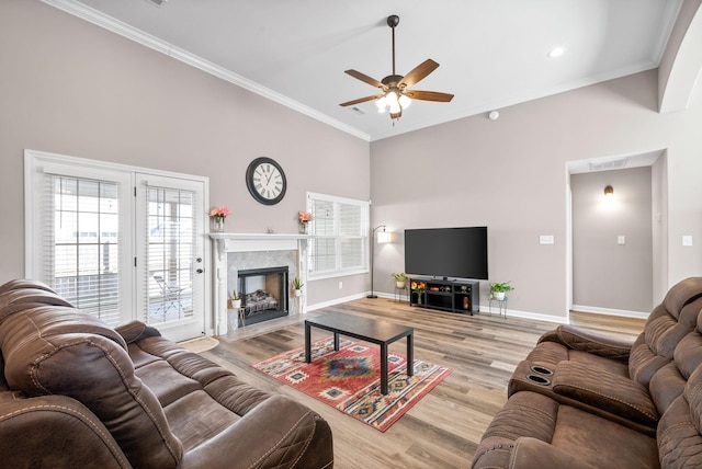 living room with light wood-type flooring, ceiling fan, and ornamental molding