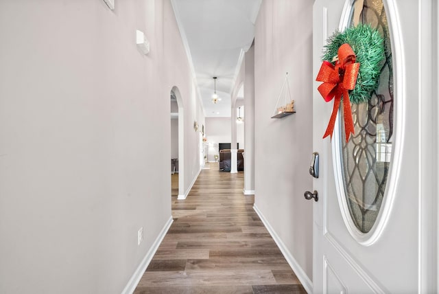 hall with light hardwood / wood-style flooring and crown molding