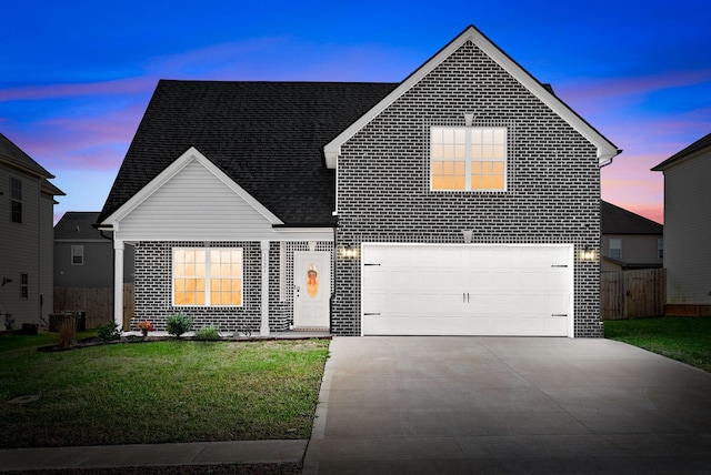 front of property featuring a yard and a garage