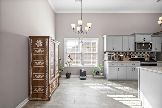 kitchen with a chandelier, pendant lighting, gray cabinets, decorative backsplash, and appliances with stainless steel finishes