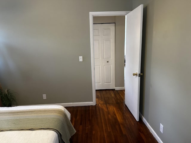 unfurnished bedroom with dark wood-type flooring and a closet