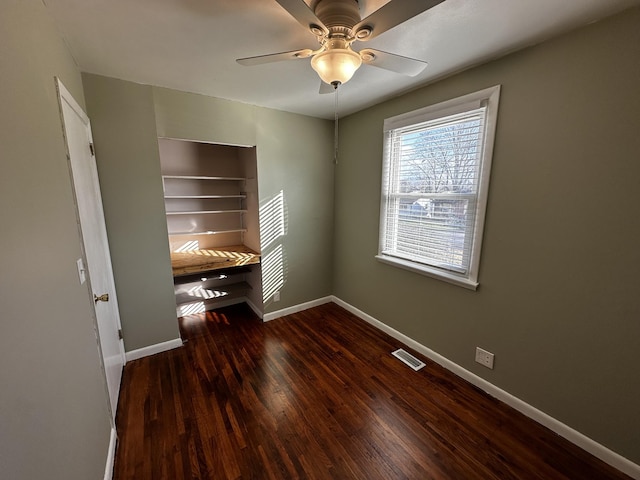 unfurnished bedroom featuring ceiling fan and dark hardwood / wood-style flooring