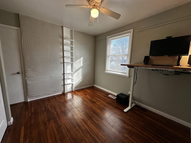 unfurnished bedroom featuring ceiling fan and dark wood-type flooring