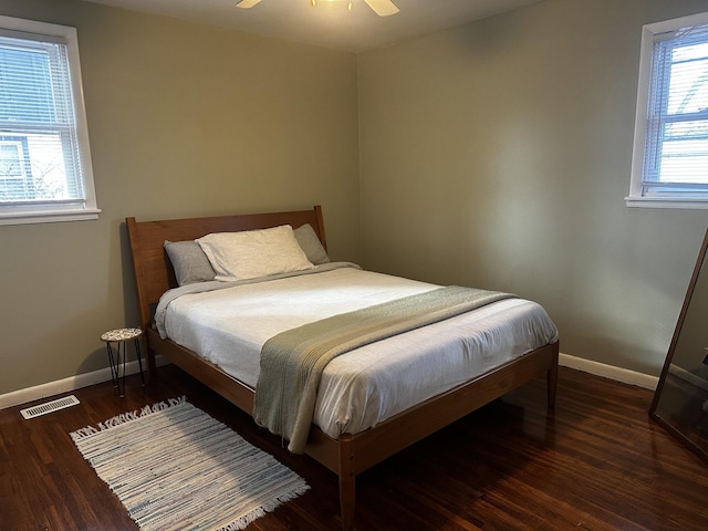 bedroom with multiple windows, ceiling fan, and dark wood-type flooring