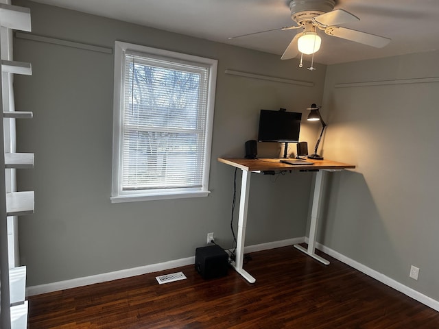 unfurnished office with ceiling fan and dark wood-type flooring