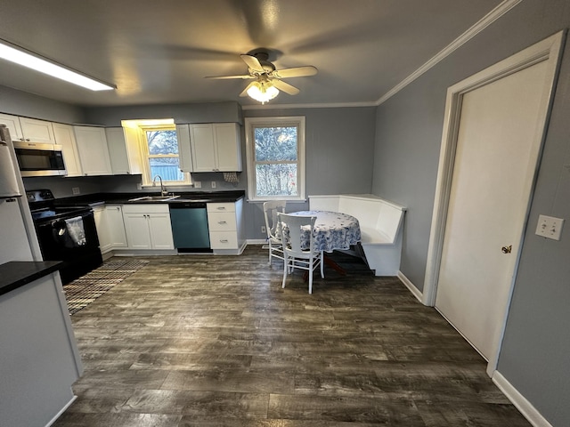 kitchen with sink, dark hardwood / wood-style flooring, crown molding, white cabinets, and appliances with stainless steel finishes