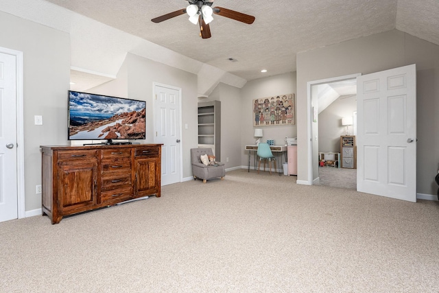 interior space with a textured ceiling, light colored carpet, vaulted ceiling, and ceiling fan