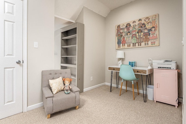 carpeted home office with vaulted ceiling