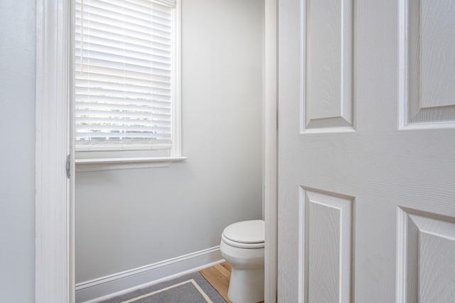 bathroom with hardwood / wood-style floors and toilet