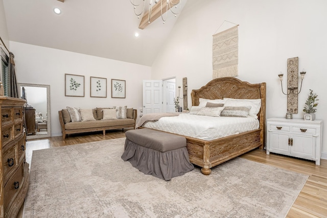 bedroom featuring beamed ceiling, high vaulted ceiling, and wood-type flooring