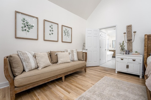 living room with high vaulted ceiling and light hardwood / wood-style floors