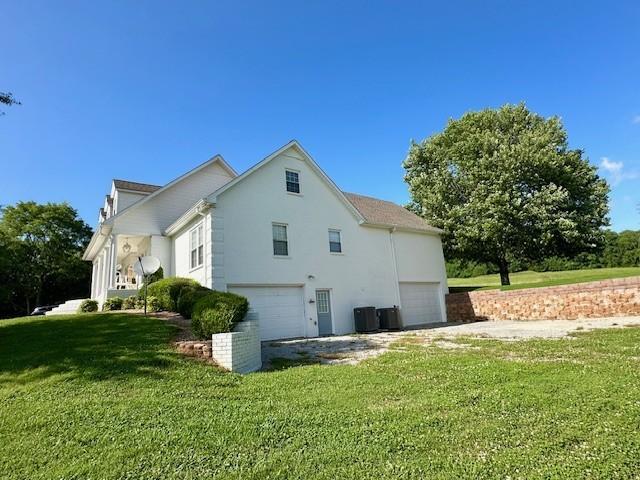 view of home's exterior with a garage and a yard