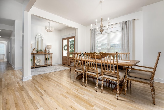 dining space with hardwood / wood-style floors and an inviting chandelier