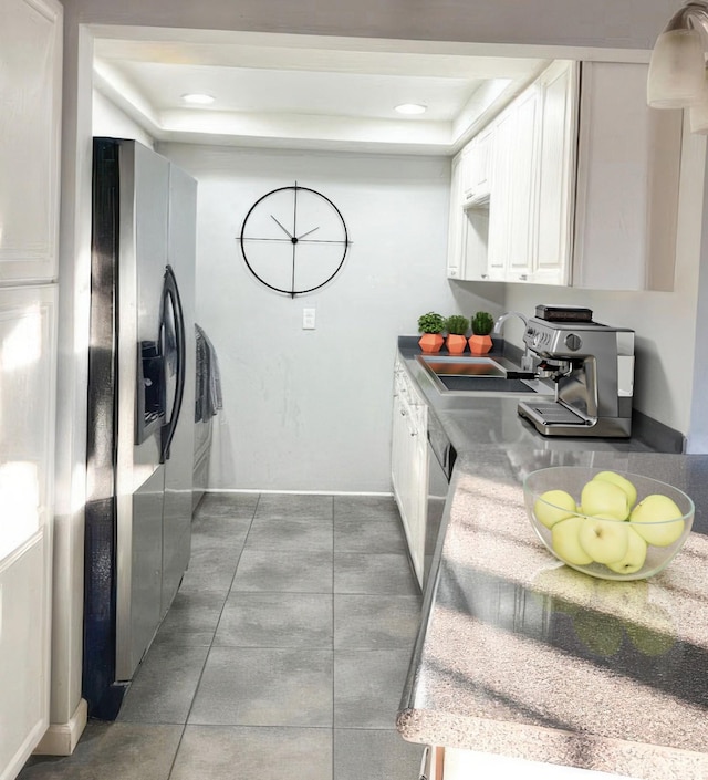 kitchen with sink, white cabinets, a tray ceiling, and appliances with stainless steel finishes