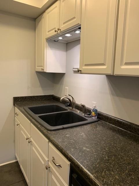 kitchen featuring sink, white cabinets, and dark tile patterned floors