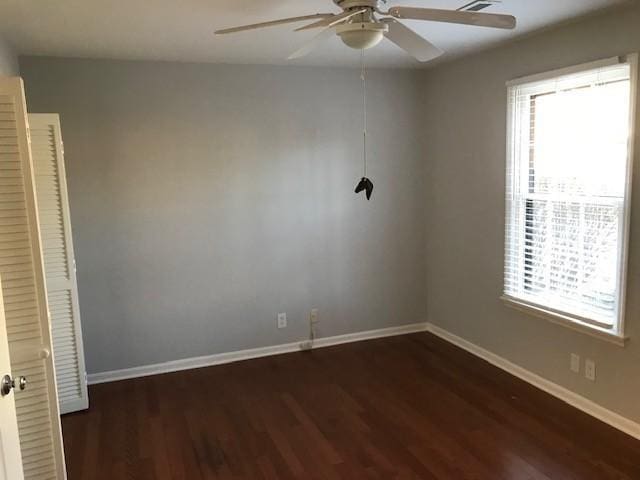 unfurnished room featuring ceiling fan and dark wood-type flooring