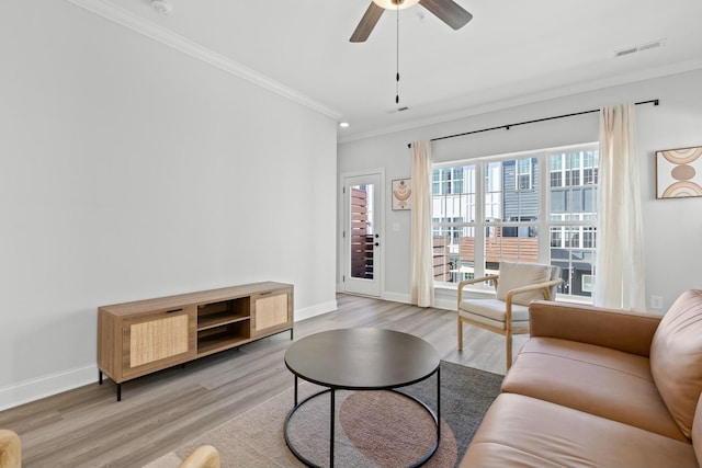 living room with crown molding, light hardwood / wood-style flooring, and ceiling fan