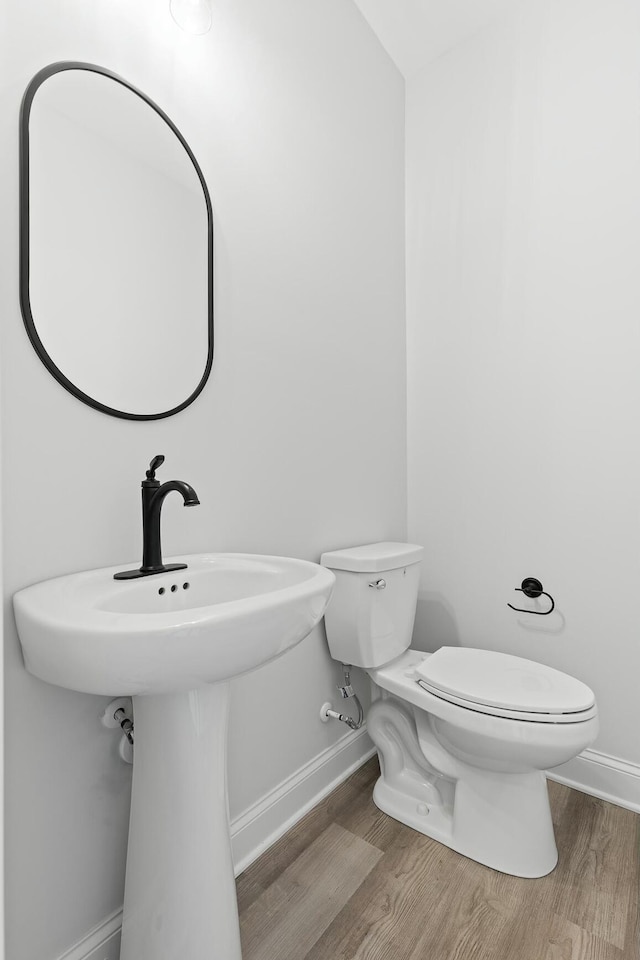 bathroom featuring toilet and wood-type flooring