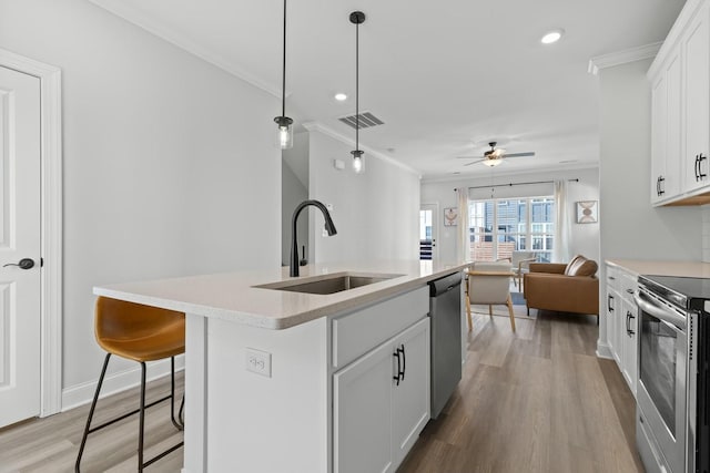 kitchen with sink, ceiling fan, an island with sink, appliances with stainless steel finishes, and white cabinetry