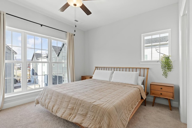 bedroom with carpet flooring, ceiling fan, and multiple windows