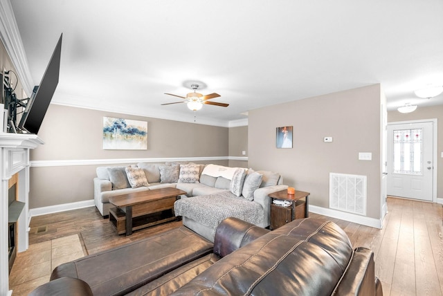 living room featuring ceiling fan, light hardwood / wood-style floors, and ornamental molding